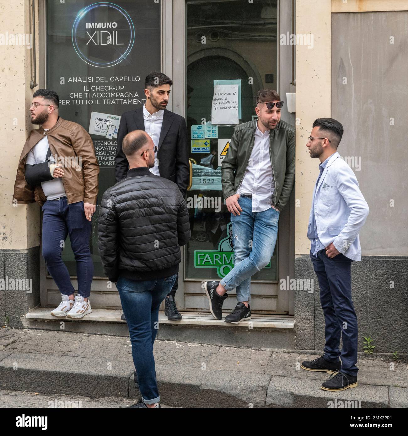 Eine Gruppe junger sizilianischer Männer in einer Dorfstraße, Sizilien, Italien Stockfoto