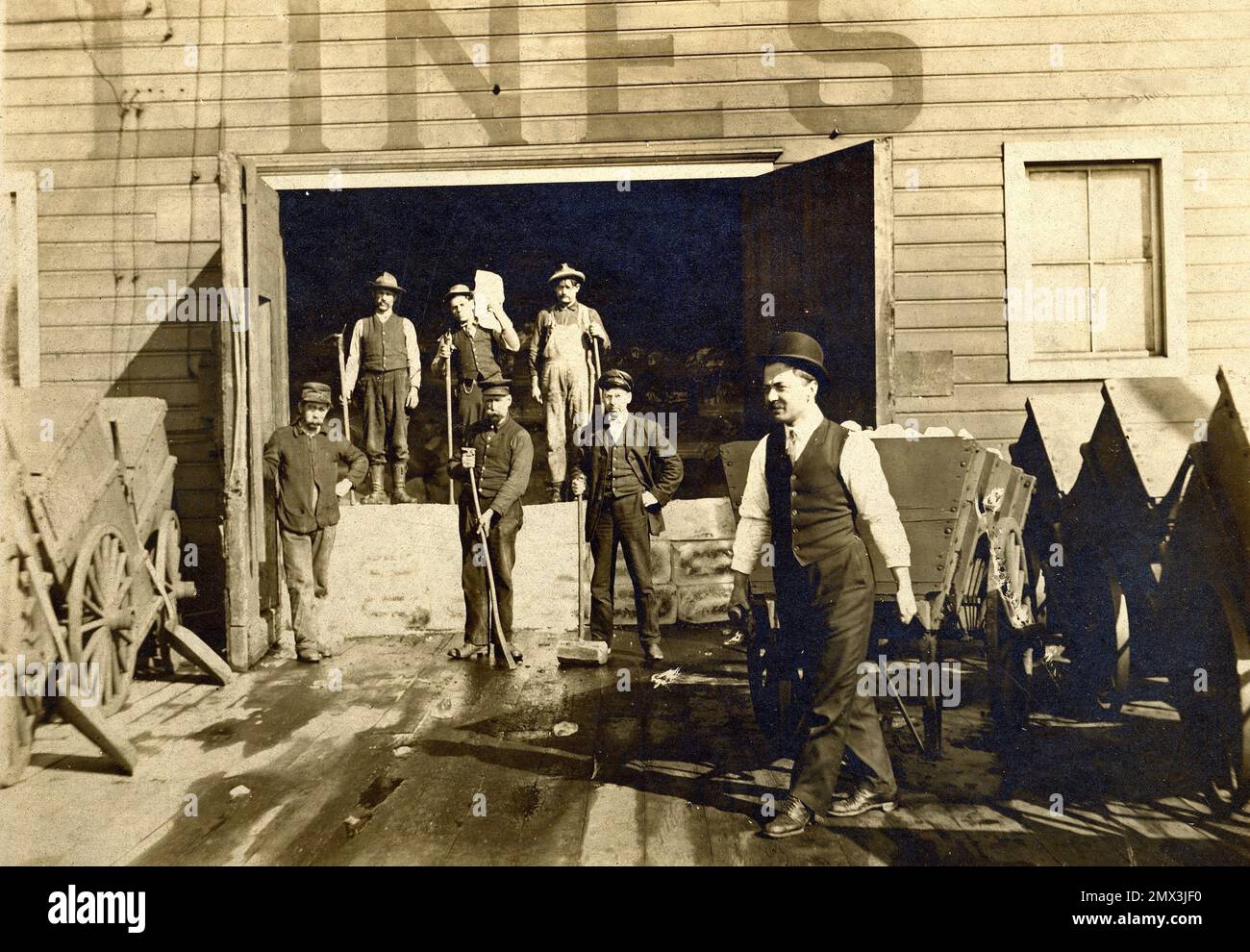 Eisbahnarbeiter, alte Eisbahnhaltestelle für Panzerwagen, Eisstation ca. 1900, Männer, die Eis in Zugwagen laden. Um die Jahrhundertwende. Stockfoto