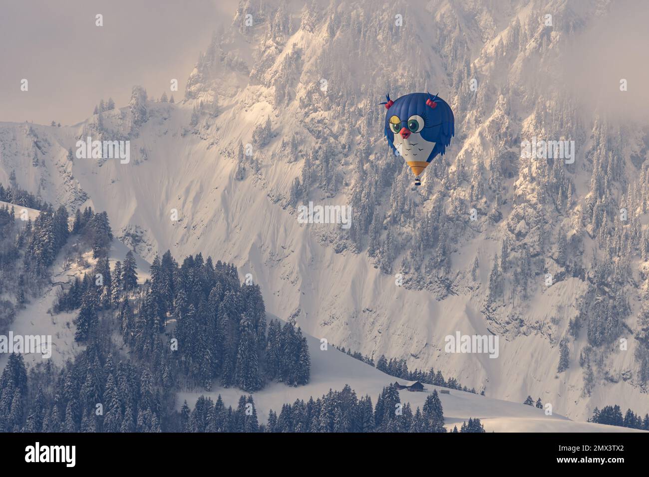 Heißluftballon. Eine Vogelform Heißluftballonfahrt, die im Winter gegen schneebedeckte Berge fliegt. Chateau-d'Oex, Vaud, Schweiz. Stockfoto