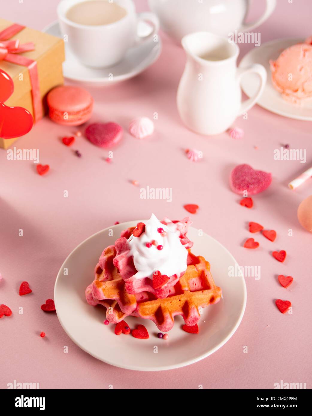 Hausgemachte rosa Waffeln mit Schlagsahne. Valentinstag, Muttertag-Konzept. Leckeres Frühstück Stockfoto
