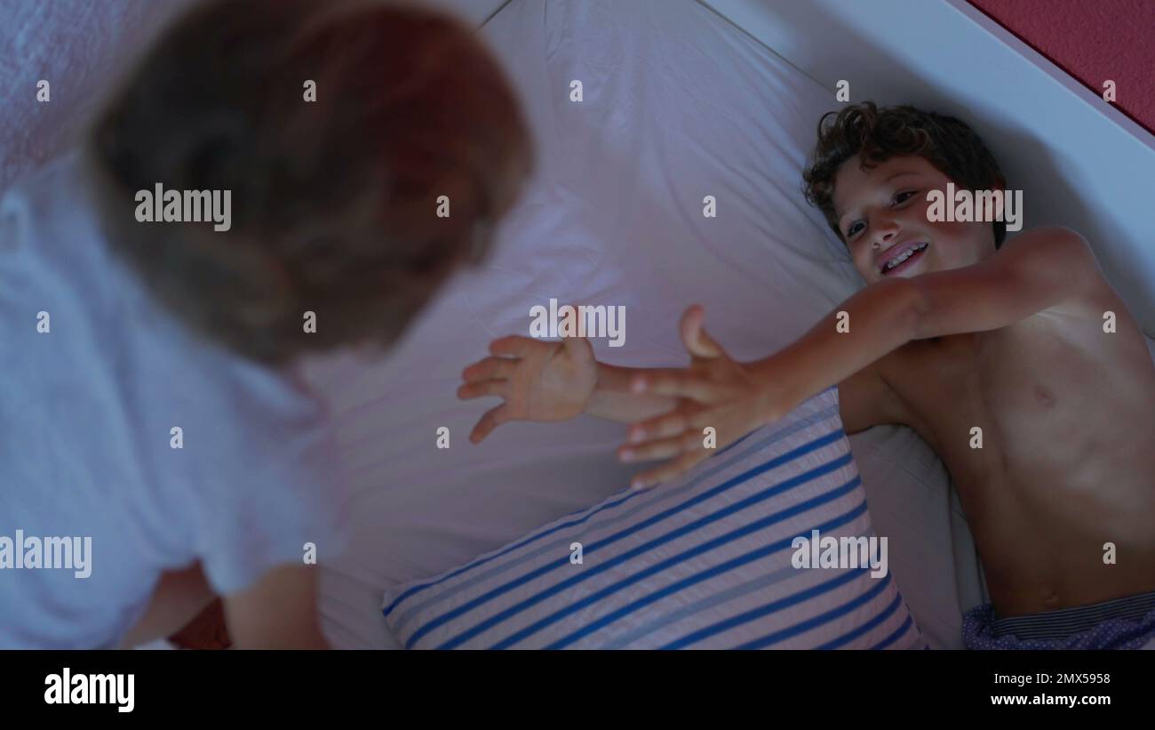 Zwei glückliche Brüder im Morgenbett, die zusammen abhängen. Authentische Geschwister, die sich am Wochenende amüsieren Stockfoto