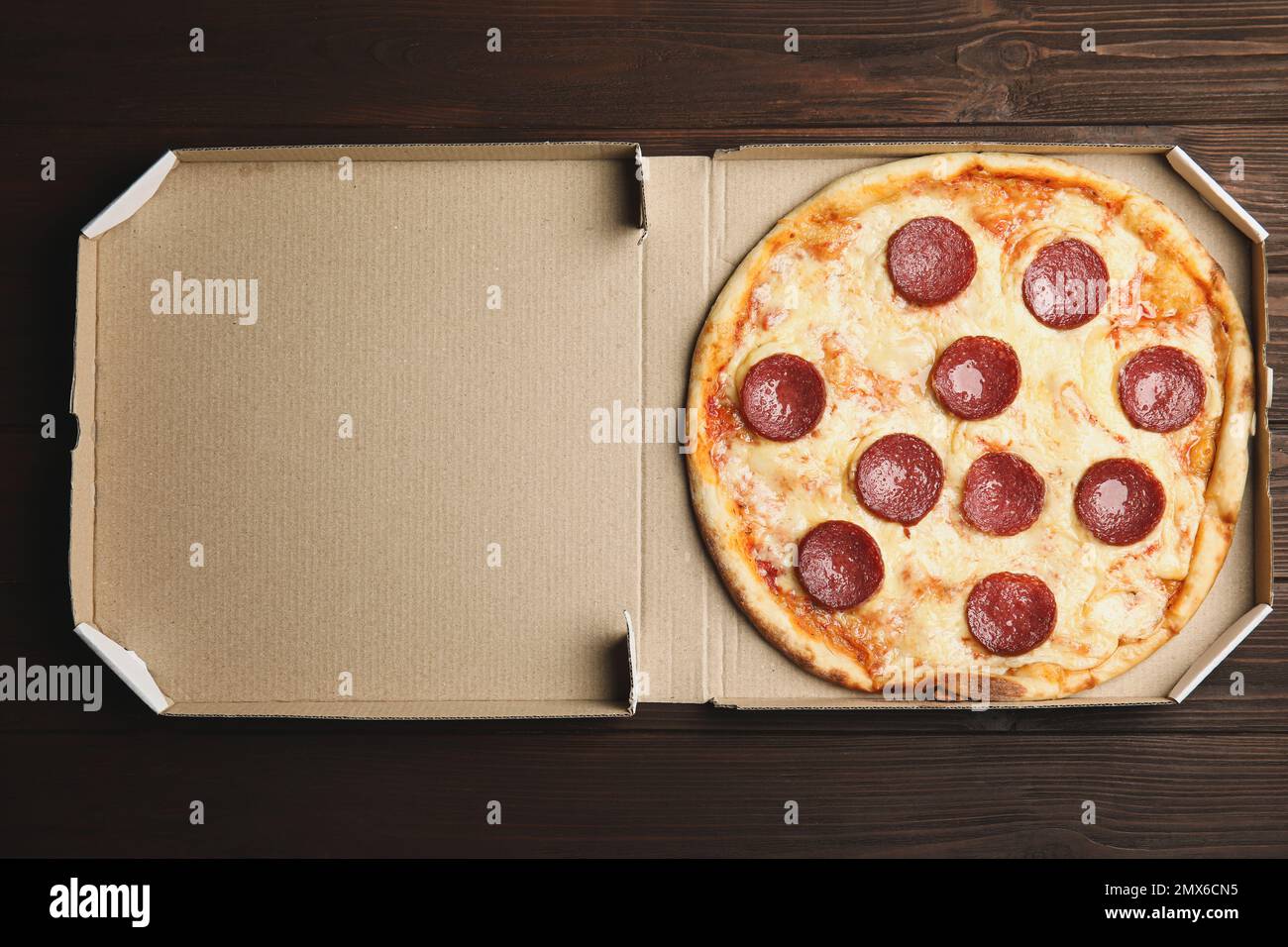 Leckere Peperoni Pizza in Pappschachtel auf Holztisch, Draufsicht Stockfoto
