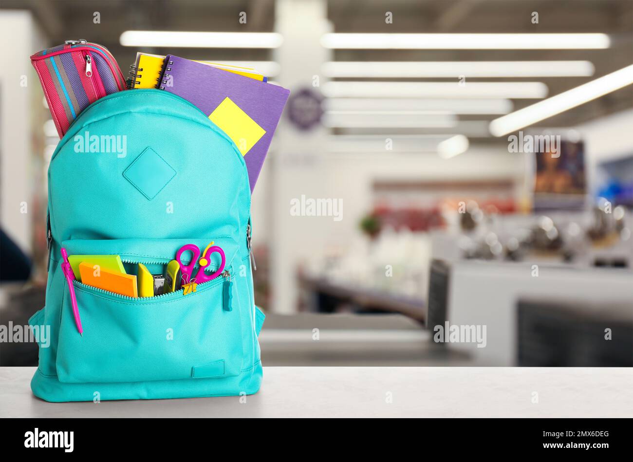 Heller Rucksack mit Schulpapier auf dem Tisch im Einkaufszentrum. Platz für Text Stockfoto
