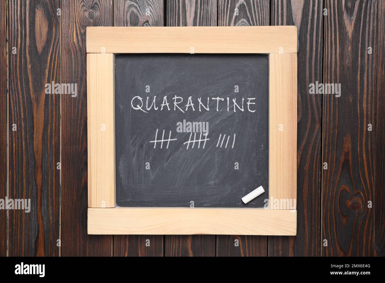 Tafel mit Kreide auf Holzhintergrund, Draufsicht. Zählung der Quarantänetage während des Coronavirus-Ausbruchs Stockfoto