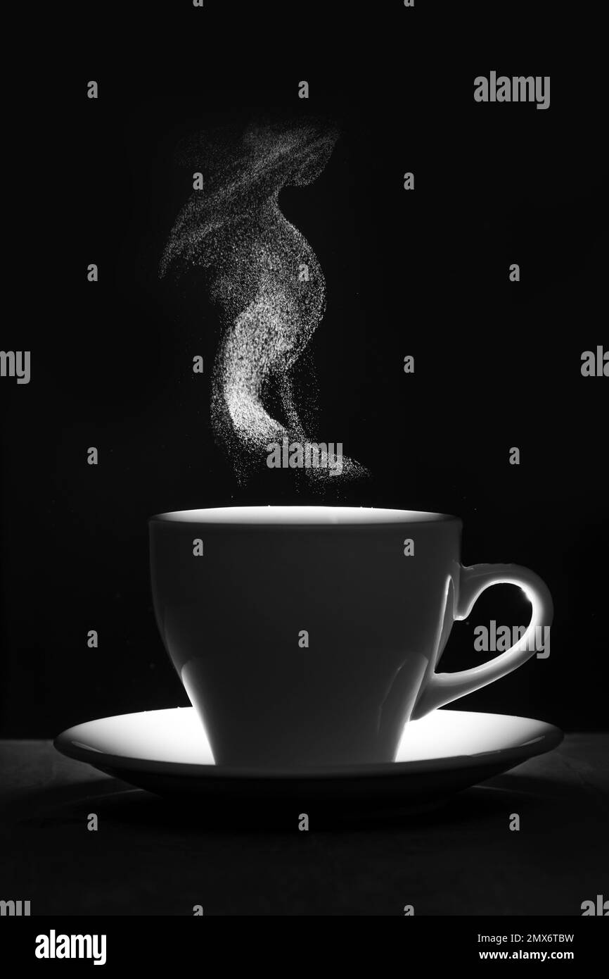 Eine weiße Tasse warmes Getränk und Dampf. Dampfgaren der Kaffeetasse auf schwarzem Hintergrund, Silhouette. Eine Tasse heißer Kaffee mit selektivem Dampfgaren. Morgen C. Stockfoto