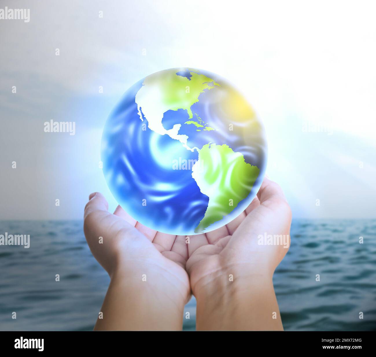 Eine Frau, die die Erde nahe dem Meer hält, Nahaufnahme Stockfoto