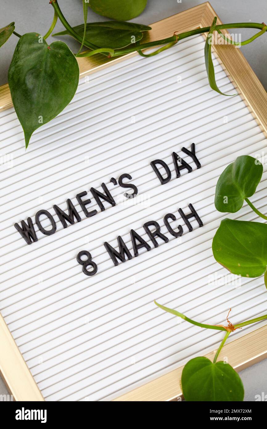Internationaler Frauentag, Schild mit der Aufschrift „Frauentag 8. März“ auf grau mit botanischen Elementen Stockfoto