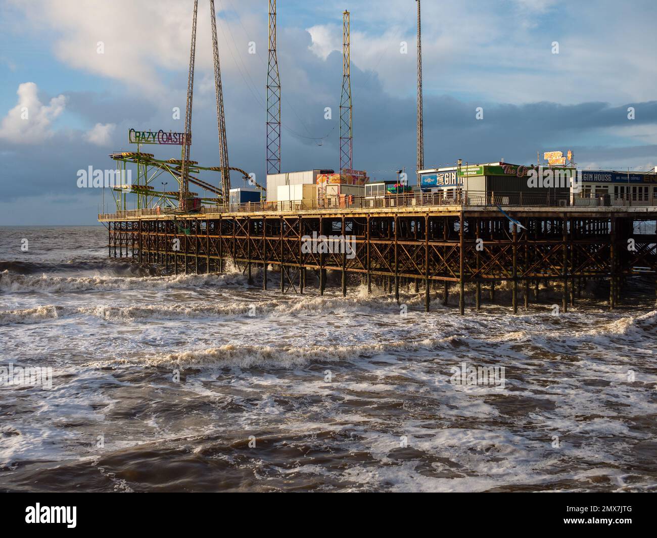 Blackpool South Pier an einem stürmischen Tag mit Wind heulen und den Wellen des irischen Meeres mit all den lustigen Fahrgeschäften geschlossen für den wilden Winter Stockfoto