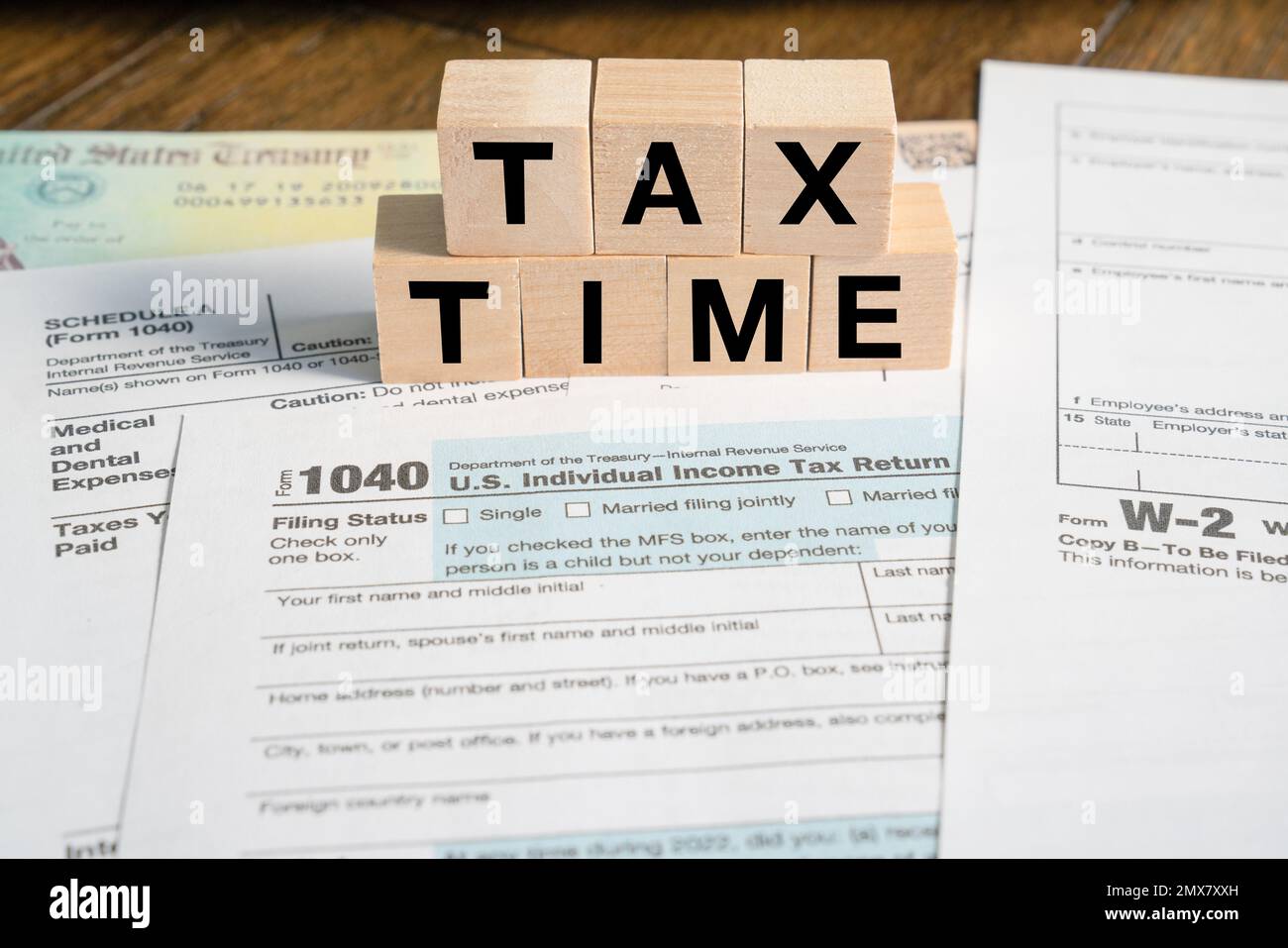 Steuerzeiterinnerung in Holzblöcken mit IRS-Formularen Stockfoto
