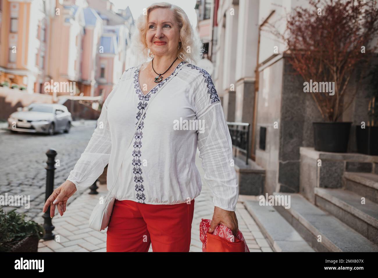 Schöne reife Frau auf einem Spaziergang in der Stadt. Außenporträt einer eleganten Frau mittleren Alters von 55 bis 60 Jahren, draußen Stockfoto