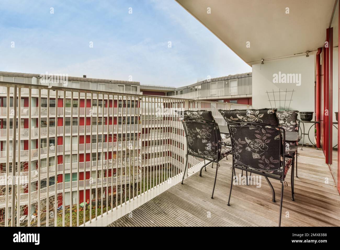 Innendesign eines modernen Balkons mit Stühlen und Tisch in der Nähe eines Glaszauns in einem Wohnviertel mit modernen Gebäuden Stockfoto