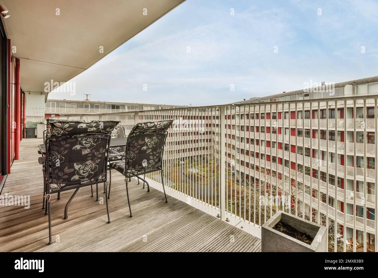 Innendesign eines modernen Balkons mit Stühlen und Tisch in der Nähe eines Glaszauns in einem Wohnviertel mit modernen Gebäuden Stockfoto