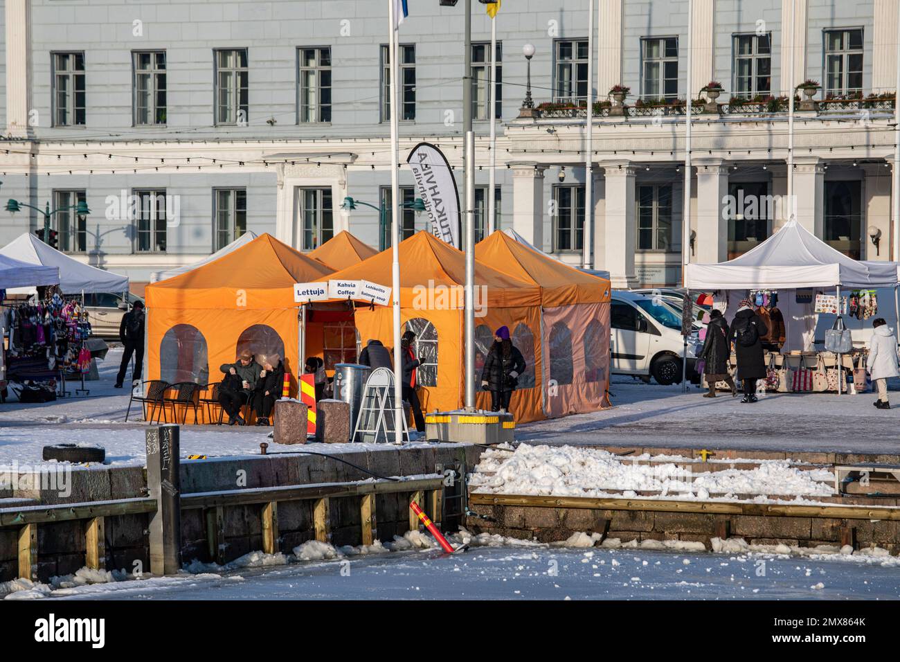 Orangefarbenes Café-Zelt am Helsinki Market Square an einem sonnigen Winternachmittag. Helsinki, Finnland. Stockfoto