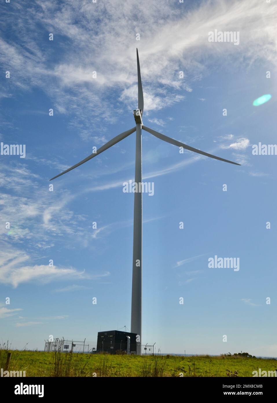 Eine einzelne hohe Windturbine, die von der Sonne am blauen Himmel in Victoria beleuchtet wird, ist Teil von Windparks, die alternative Energie oder Strom für das Netz erzeugen Stockfoto