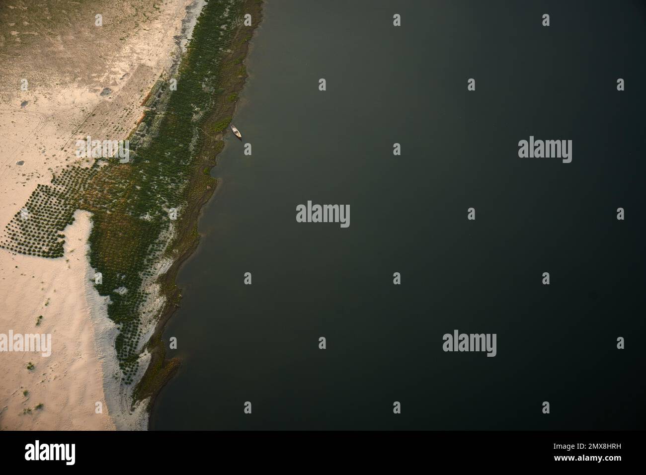 Ein Blick von oben auf ein Boot, das an den sandigen Ufern des Irrawaddy River in Myanmar (Birma) festgemacht ist. Stockfoto