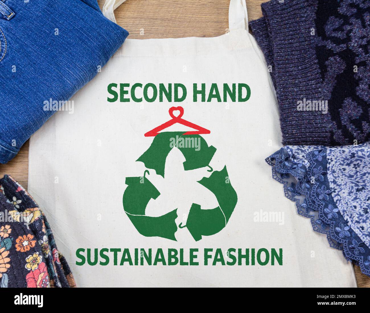 Nachhaltige Second-Hand-Mode, bedruckt auf einer wiederverwendbaren Tasche mit Blick von oben auf beliebte Kleidung Stockfoto