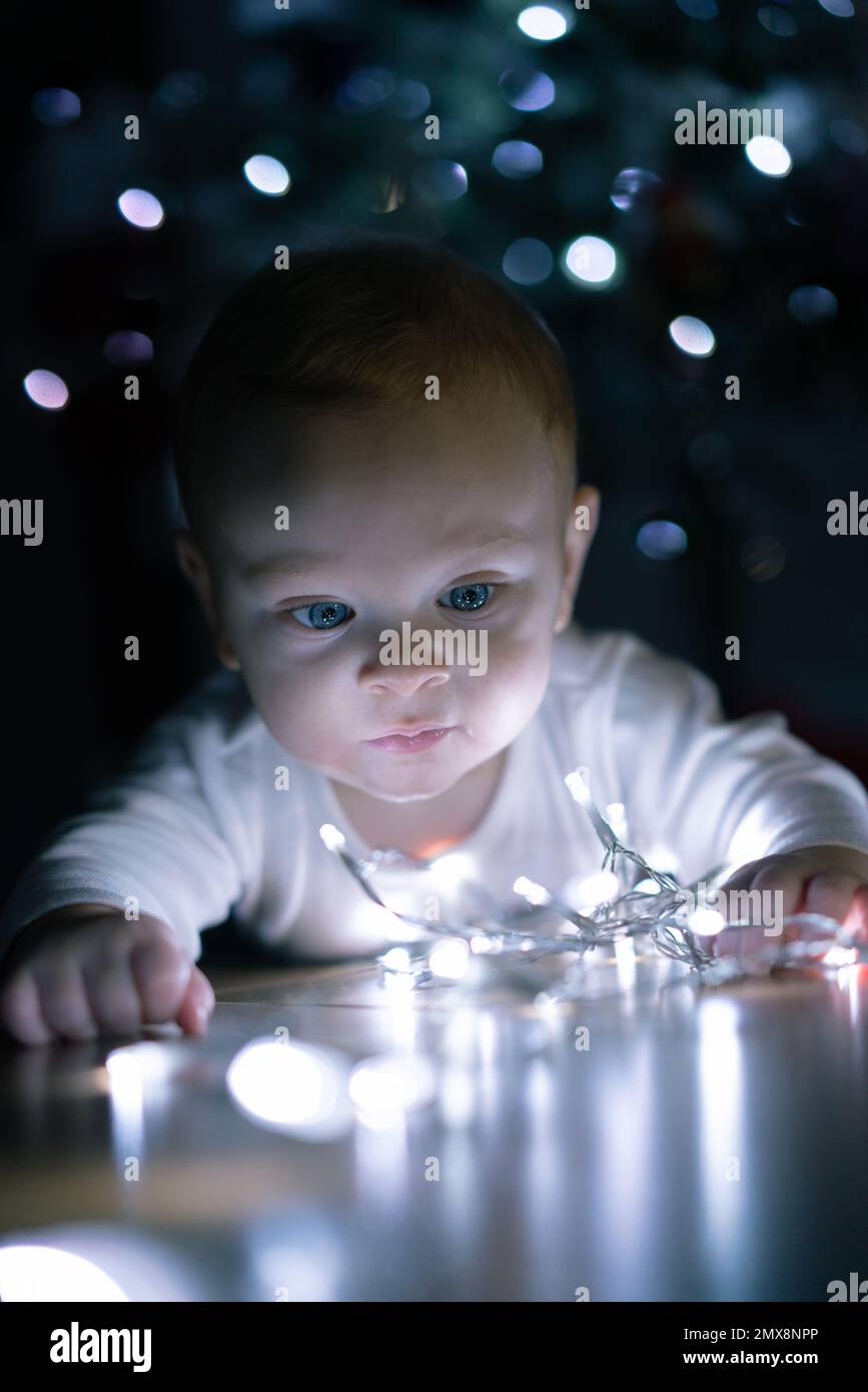 Ihr Baby erforscht Weihnachtsdekorationen Stockfoto