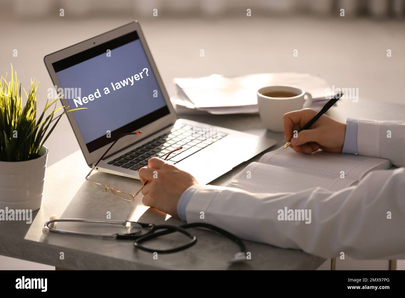 Arzt, der mit dem Laptop arbeitet, im Büro, Nahaufnahme. Brauchst du einen Anwalt? Stockfoto