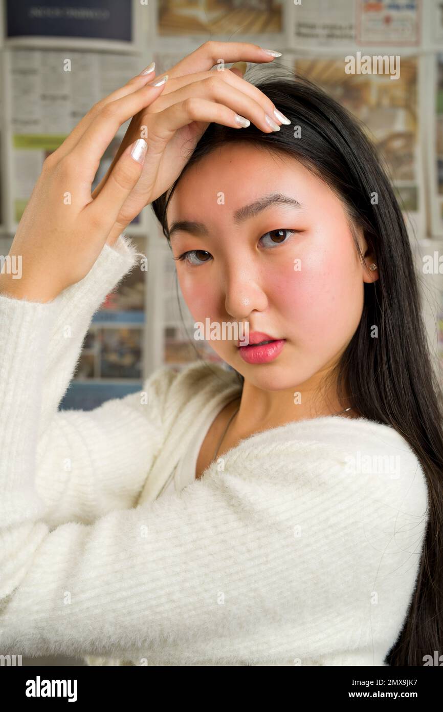 Nahaufnahme eines wunderschönen asiatischen Mädchens mit Händen, die das Gesicht umrahmen Stockfoto