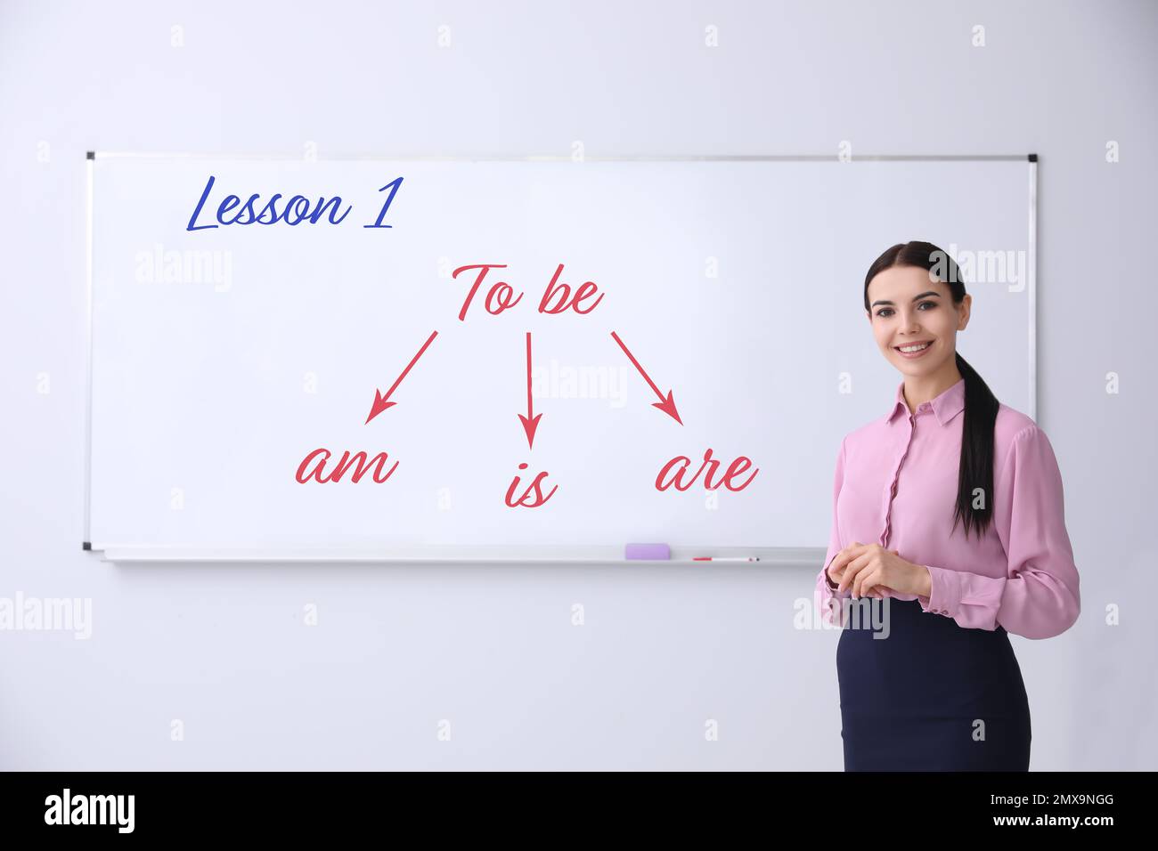 Junger Englischlehrer in der Nähe des Whiteboards im Klassenzimmer Stockfoto