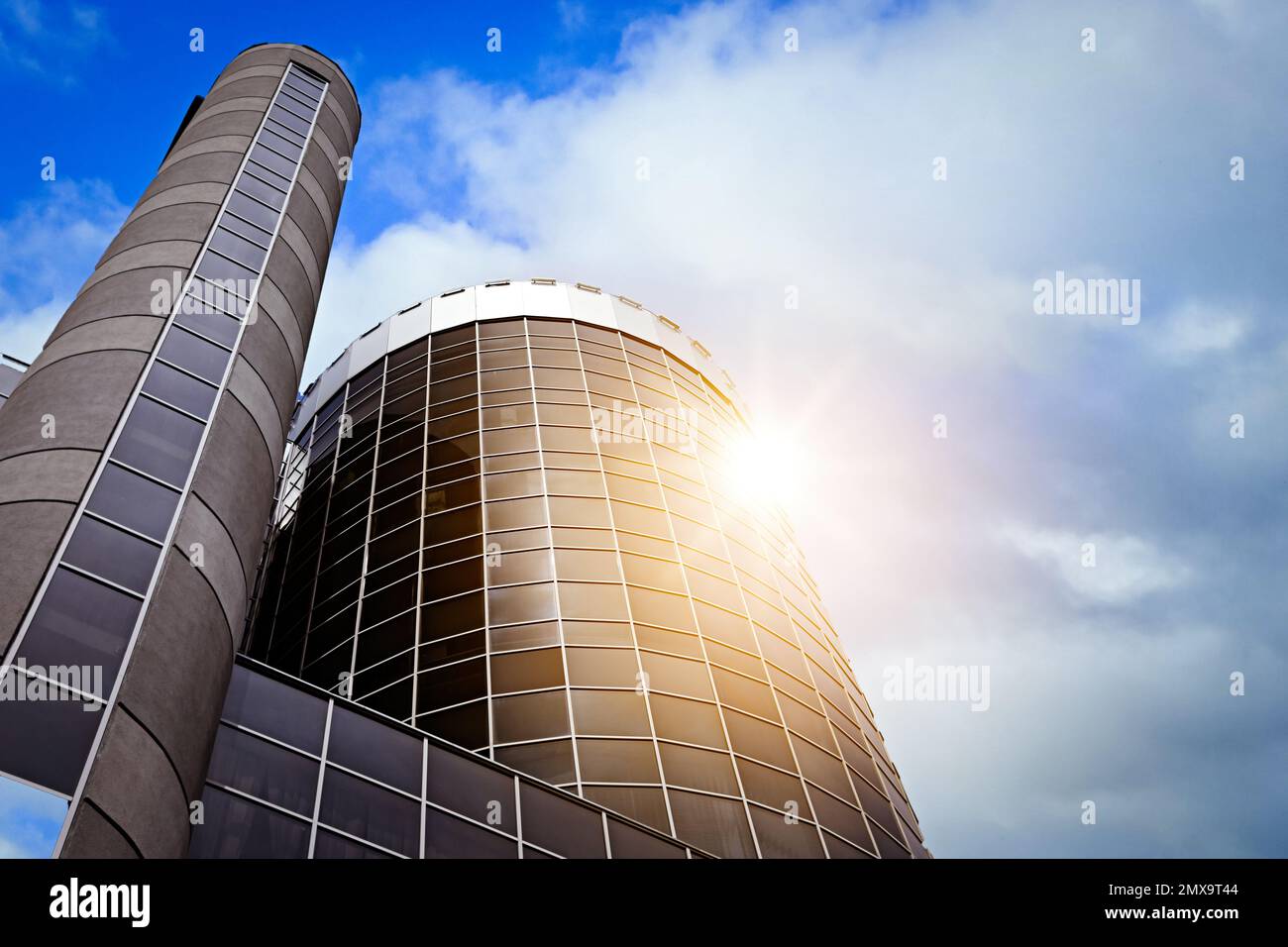 Moderner Wolkenkratzer mit getönten Fenstern vor blauem Himmel, Blick aus niedrigem Winkel. Bauunternehmen Stockfoto