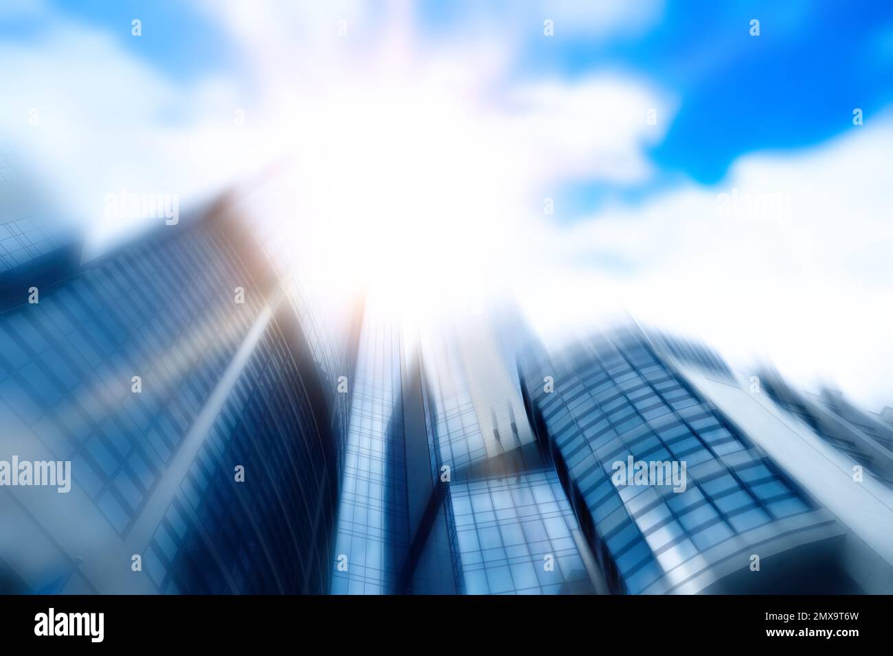Verschwommener Blick auf den modernen Wolkenkratzer mit getönten Fenstern vor blauem Himmel, Blick aus dem niedrigen Winkel. Bauunternehmen Stockfoto