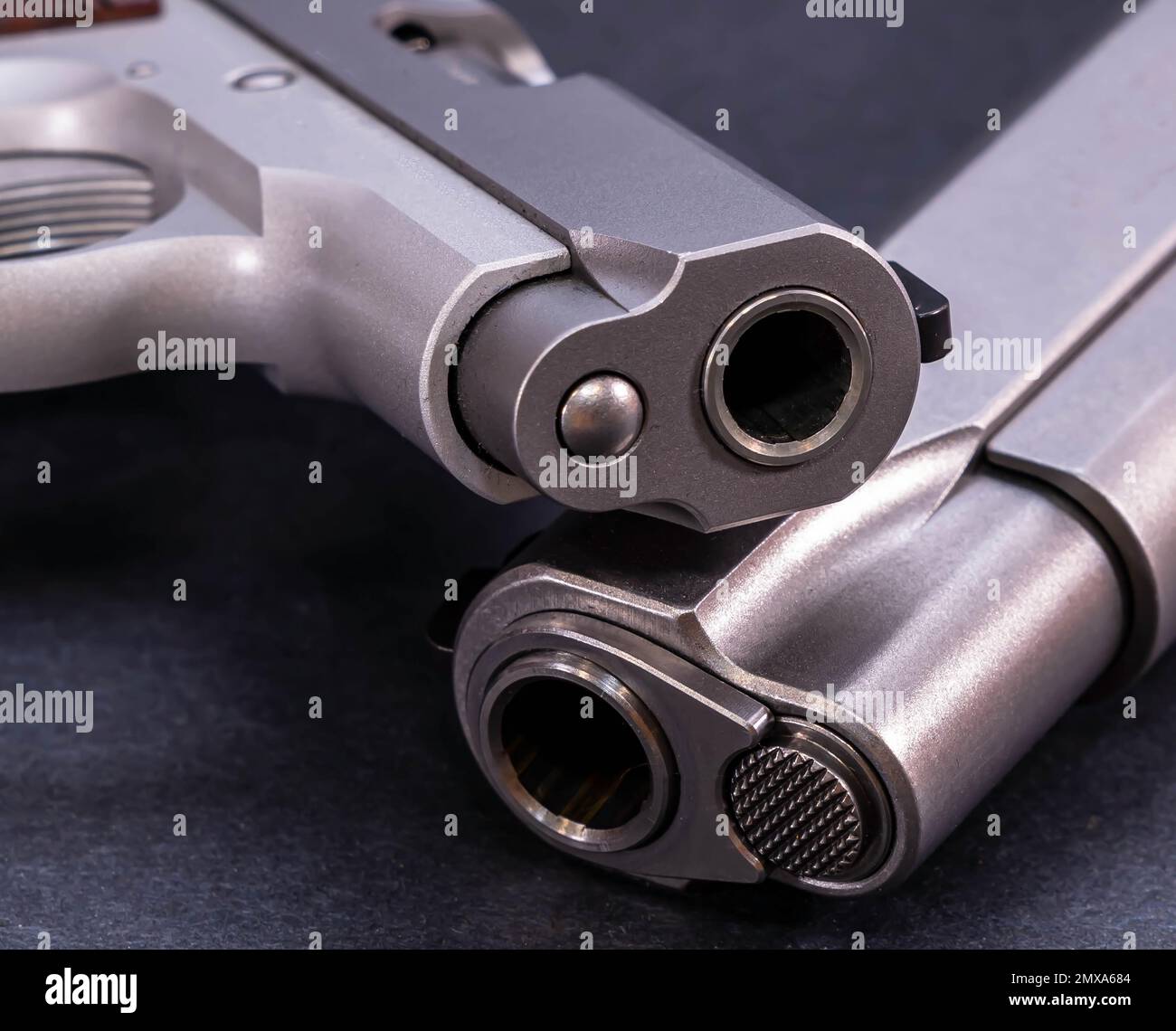 Zwei 1911-Pistolen aus rostfreiem Stahl, eine 45 ACP und die andere eine 380 Kaliber, die auf schwarzem Hintergrund gestapelt sind Stockfoto
