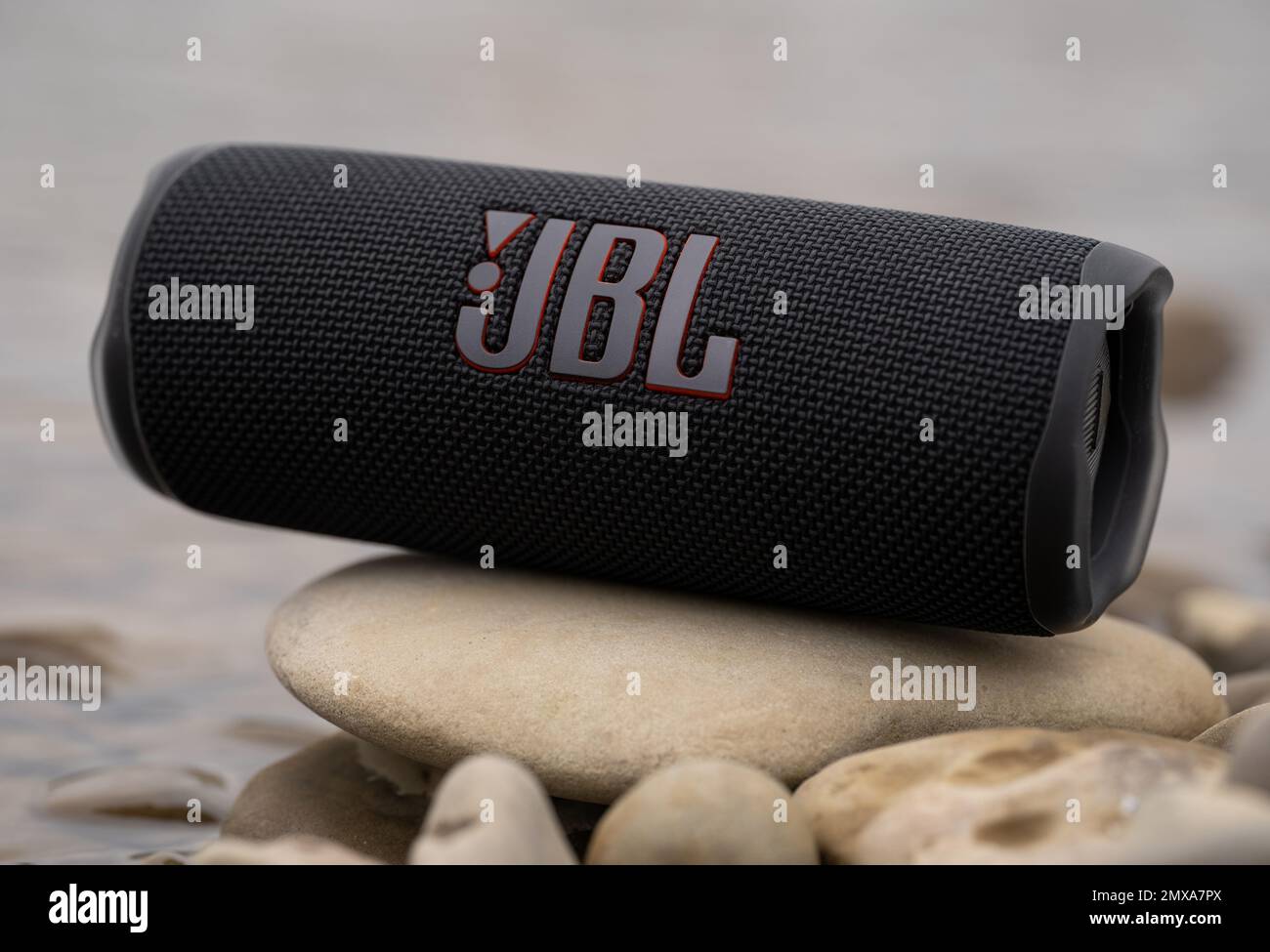 LEMBERG, UKRAINE - 12. OKTOBER 2022: JBL Flip 6 Black, tragbarer bluetooth-Lautsprecher im Freien auf den Steinen am Flussufer Stockfoto