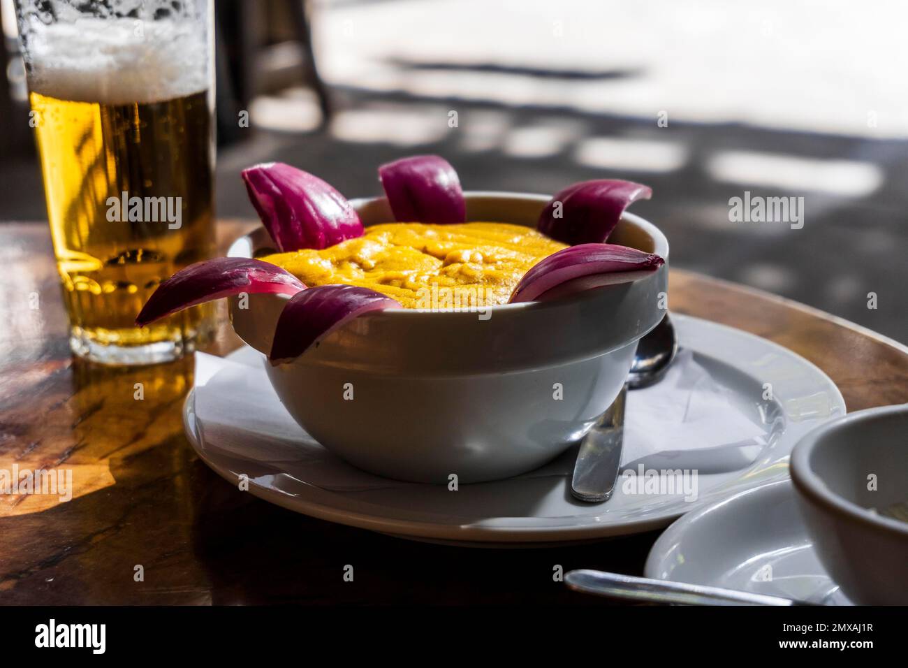 Köstliche traditionelle Speisen von Gran Canaria namens Gofio Escaldado werden mit rohen roten Zwiebeln gegessen Stockfoto