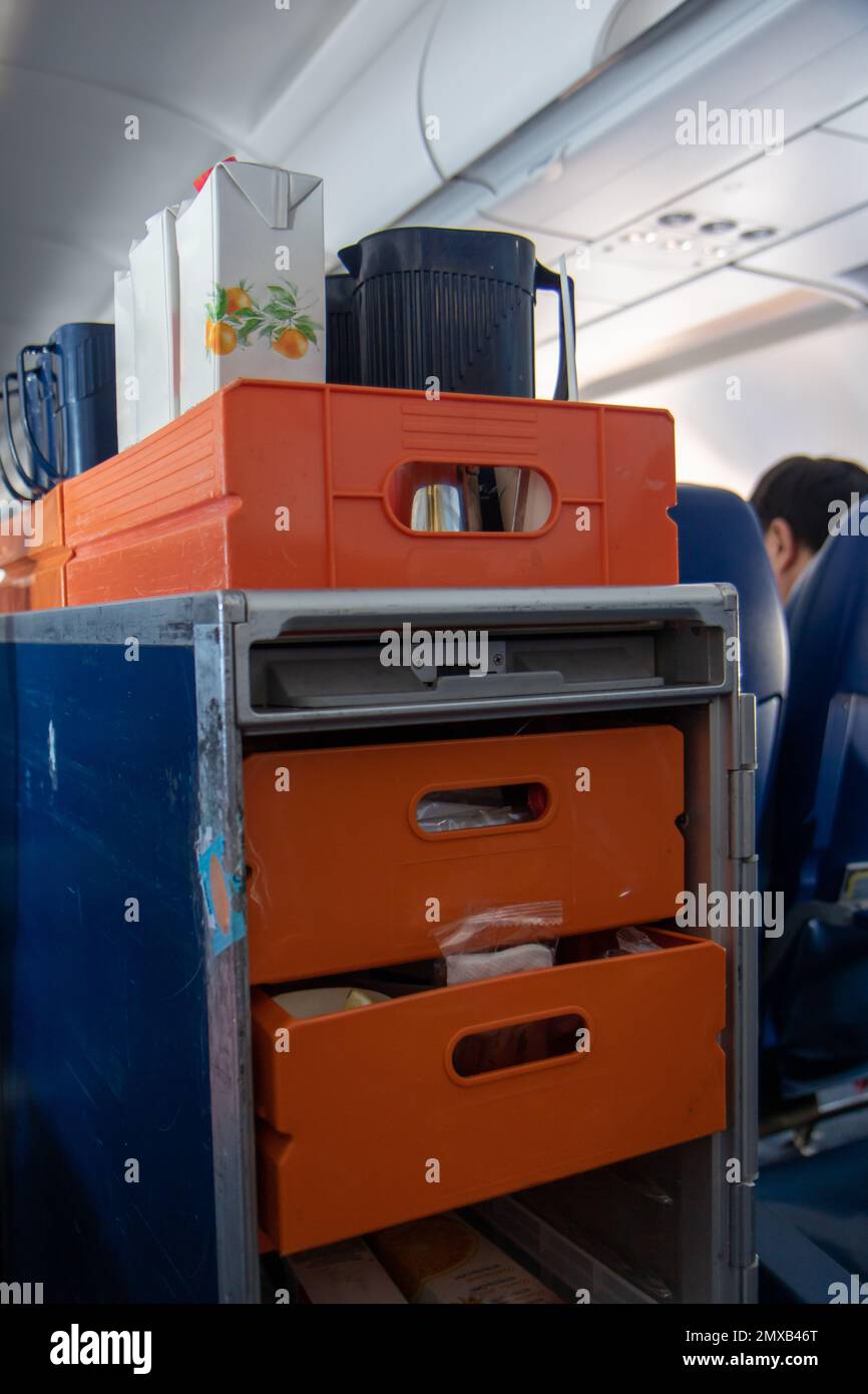 Ein Wagen mit Getränken und Snacks im Gang des Flugzeugs Stockfoto