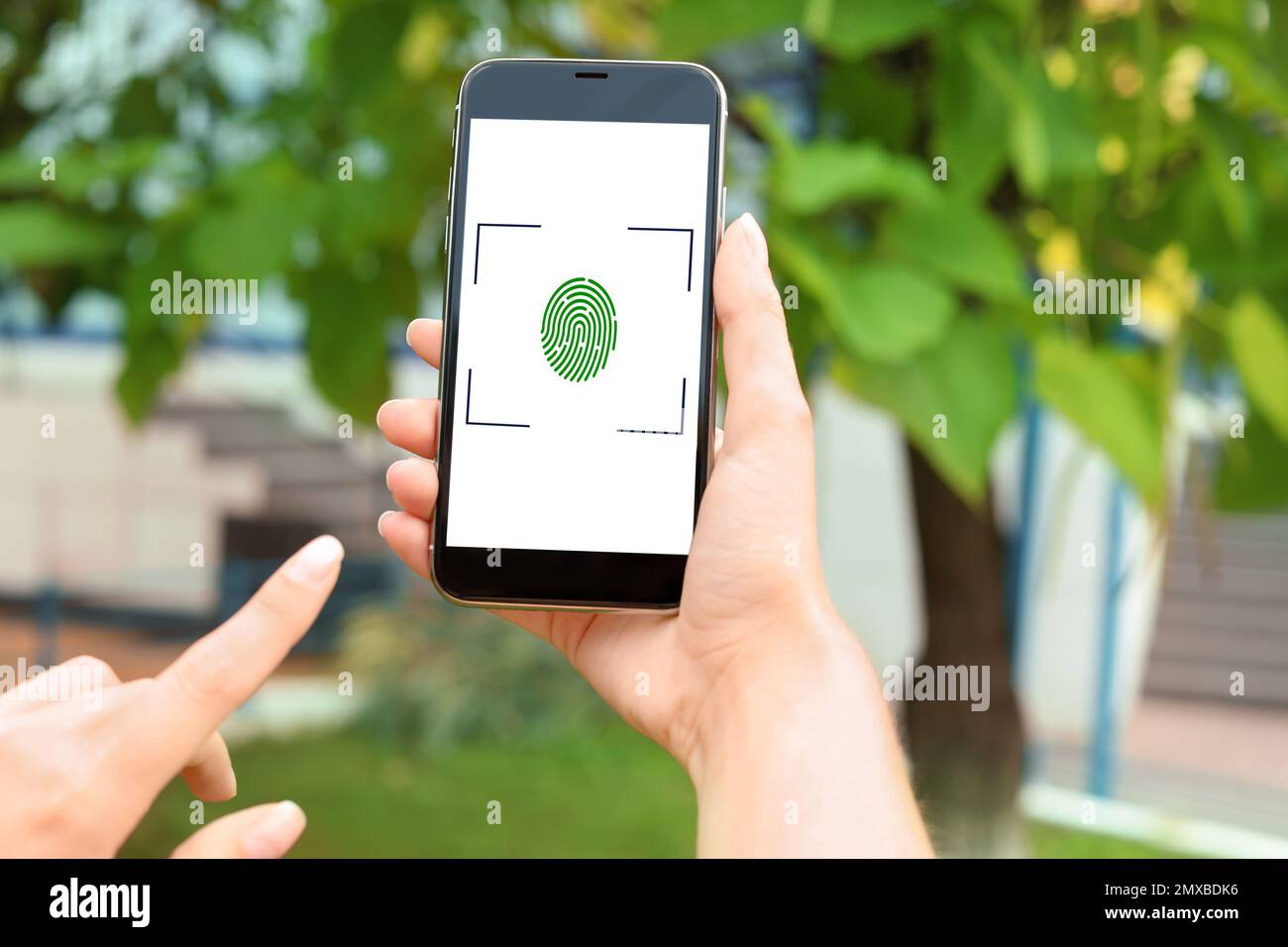 Frau mit Smartphone mit Fingerabdrucksensor im Freien, Nahaufnahme. Digitale Identität Stockfoto