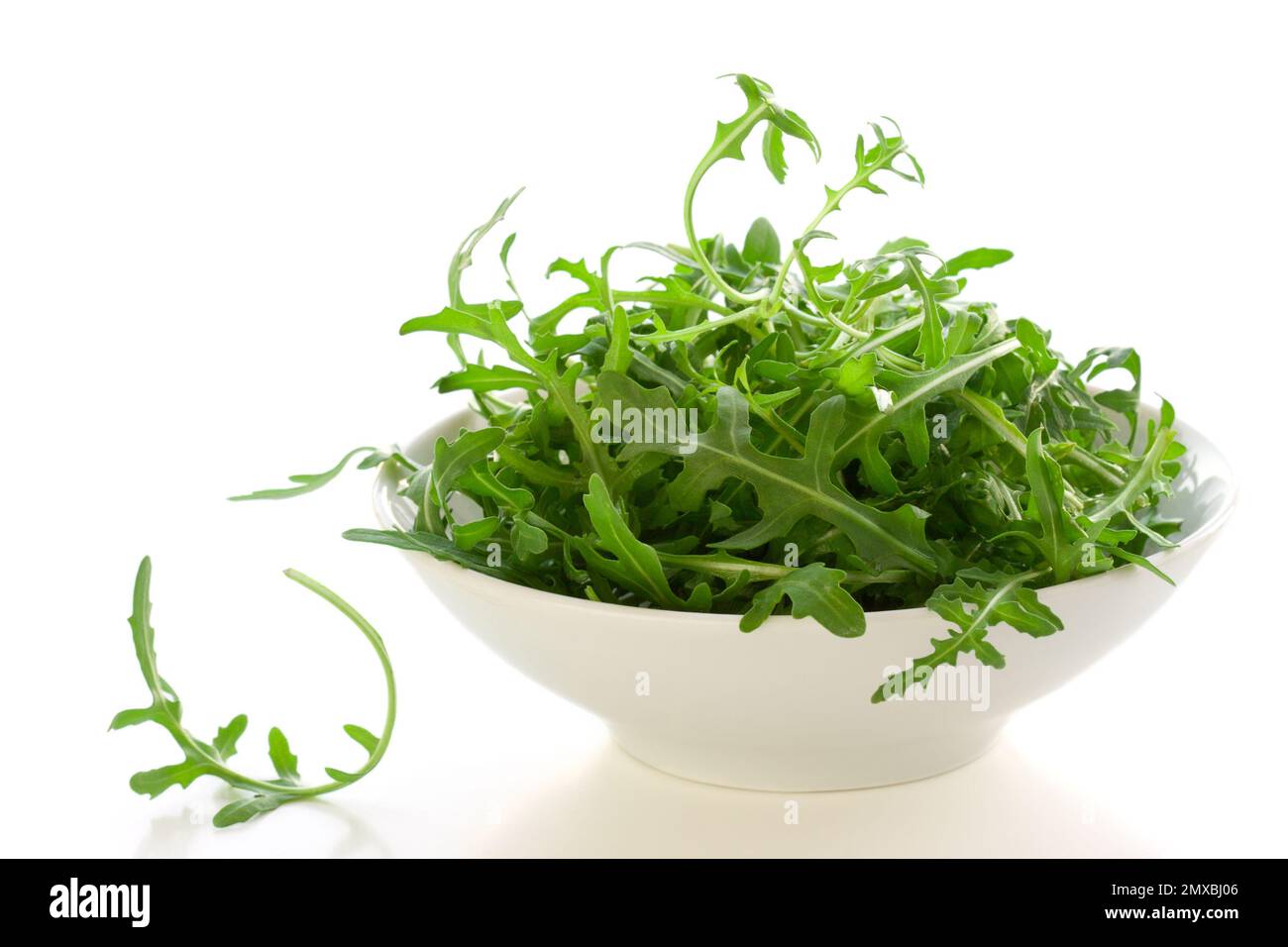 Schale mit Rucola-Blättern auf weißem Hintergrund Stockfoto