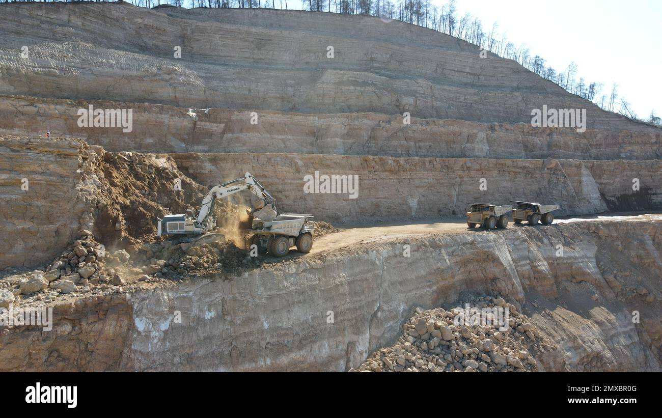 Bagger beladen Dämpfer. Sie arbeiten auf einer riesigen Baustelle. Stockfoto