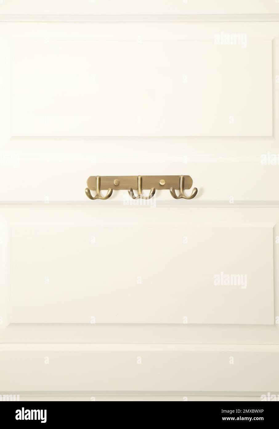 Weiße Tür mit leeren Kleiderhaken aus Metall Stockfoto