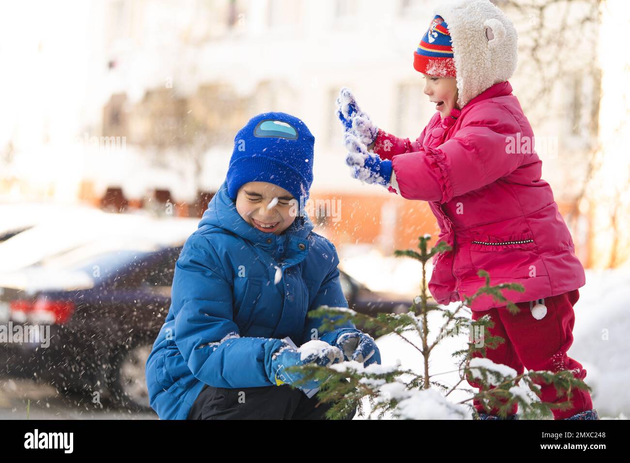 Kinder spielen im Winter in Schneebällen in warmen Jacken Stockfoto