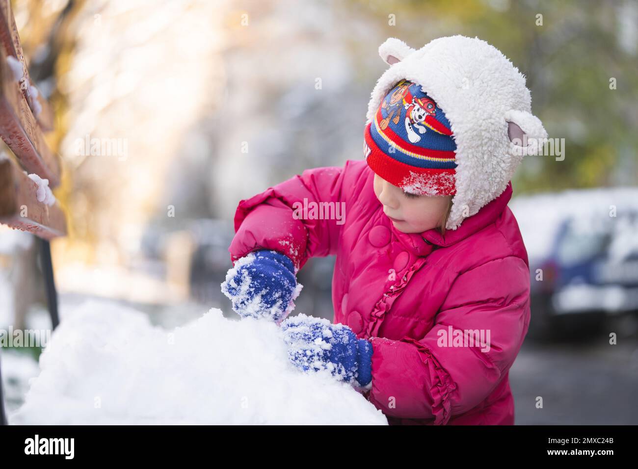 Kinder spielen im Winter in Schneebällen in warmen Jacken Stockfoto