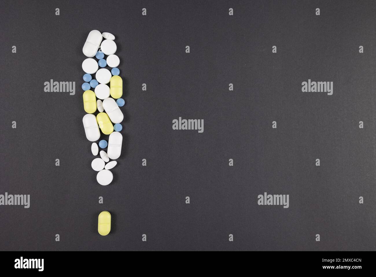 Warnschild mit Pillen und Medikamenten auf schwarzem oder grauem Hintergrund. Nebenwirkungen von Medikamenten oder toxischen Medikamenten Konzeptfoto. Stockfoto