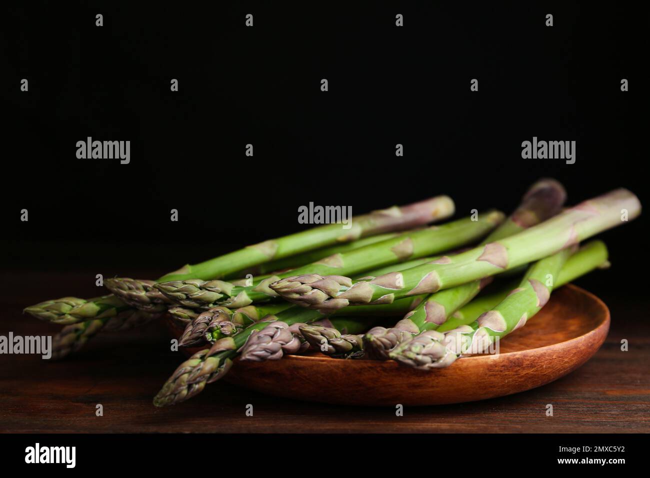 Frischer roher Spargel auf Holztisch, Nahaufnahme Stockfoto