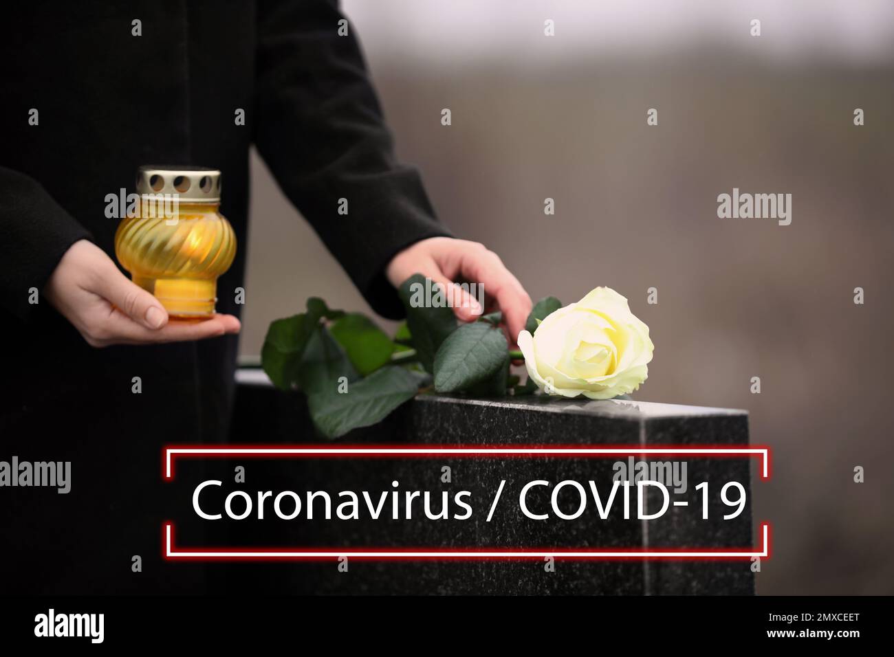 Beerdigungszeremonie für Coronavirus-Opfer. Frau mit Kerze und Rose in der Nähe des Grabsteins draußen, Nahaufnahme. Stockfoto