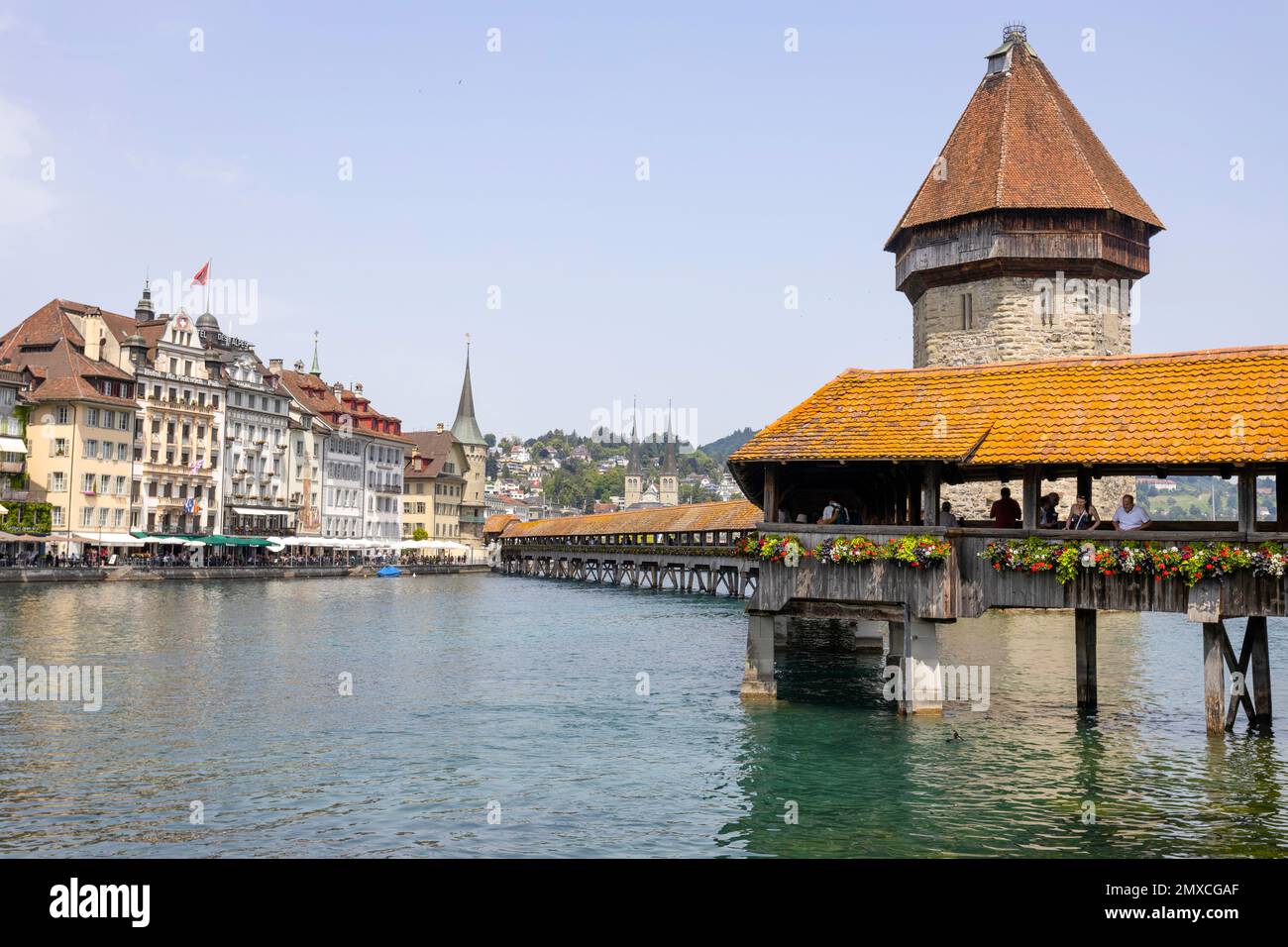 LUZERN, SCHWEIZ, 21. JUNI 2022 - Blick auf die verwundete überdachte Kapellbrücke am Fluss Reuss und die Gebäude in Luzern, Schweiz. Stockfoto