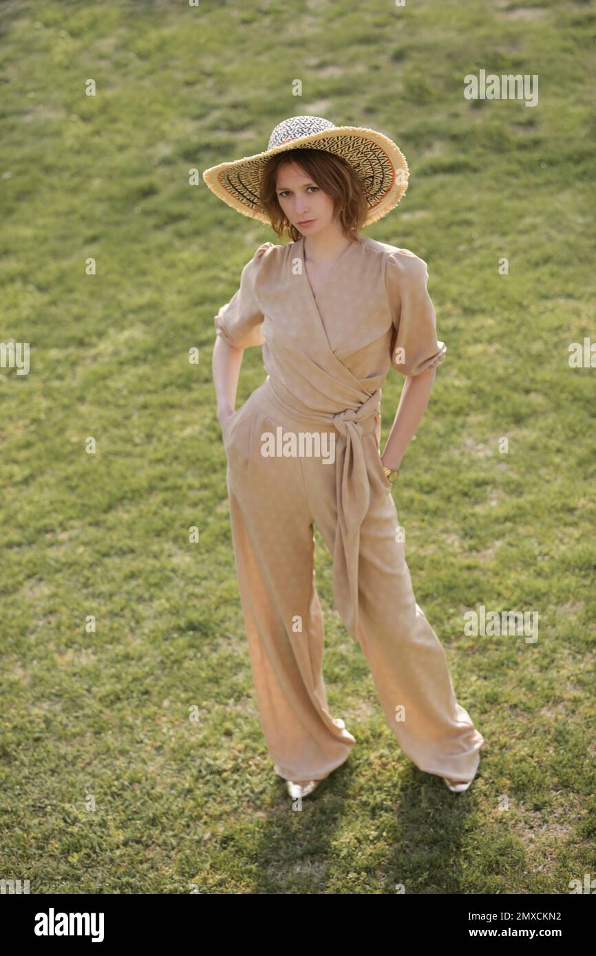 Außenporträt eines weiblichen Models in beigefarbenem Leinenkostüm Genießen Sie einen wunderschönen Sommertag im öffentlichen Park Stockfoto