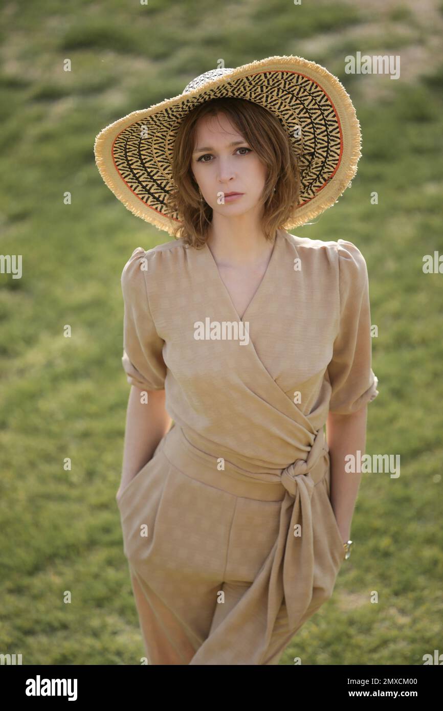 Außenporträt eines weiblichen Models in beigefarbenem Leinenkostüm Genießen Sie einen wunderschönen Sommertag im öffentlichen Park Stockfoto