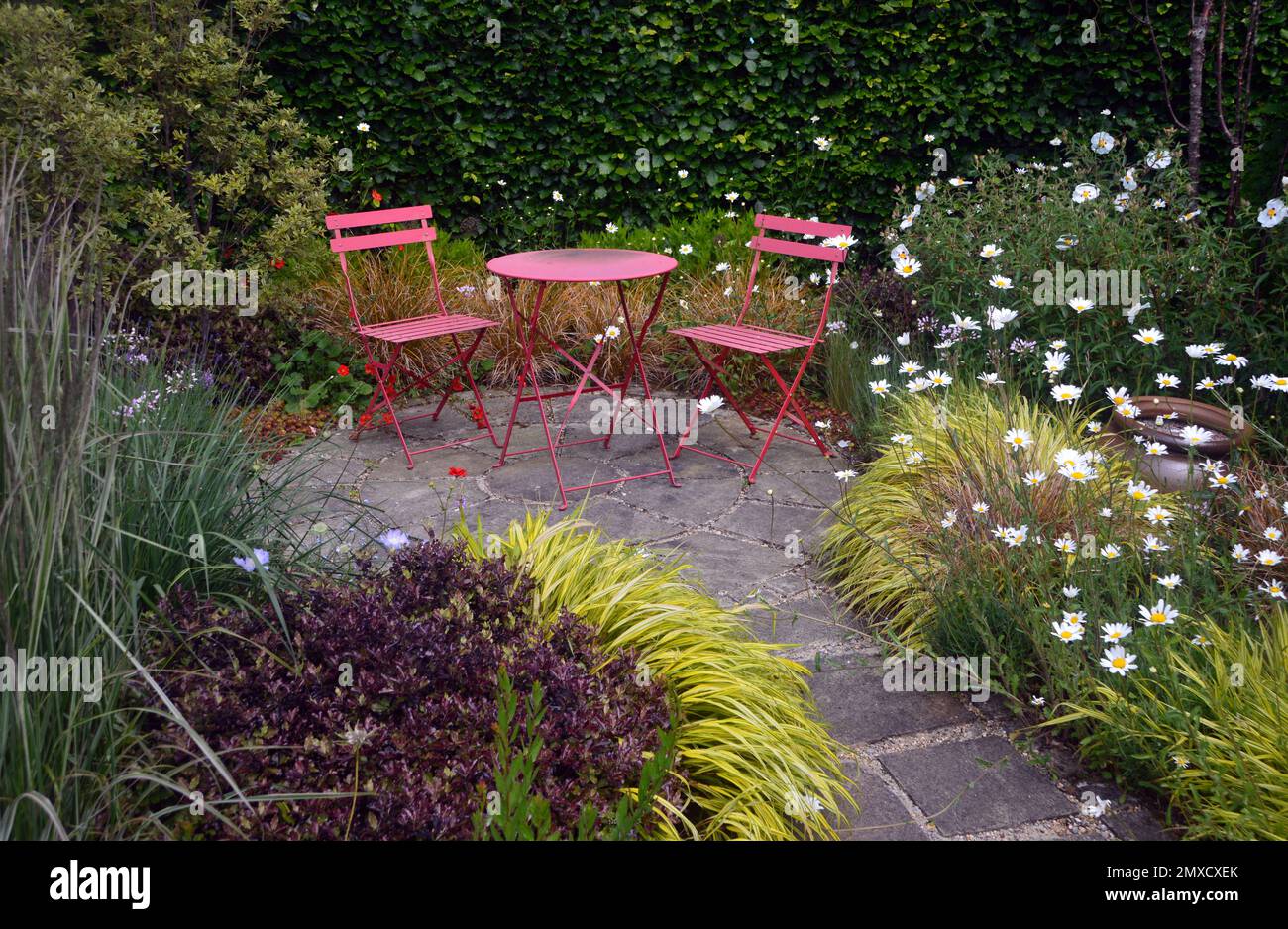 Pink Metal Patio in einer ruhigen gepflasterten Gegend im RHS Garden Harlow Carr, Harrogate, Yorkshire, Großbritannien Stockfoto