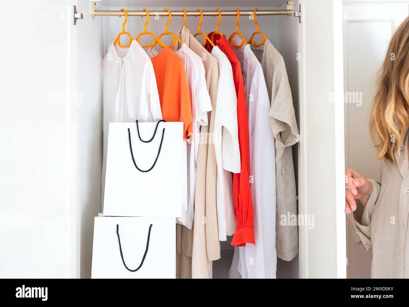 Frauen öffnen die Schranktür zu Choice Kleidung im Schrank in der Garderobe. Stockfoto