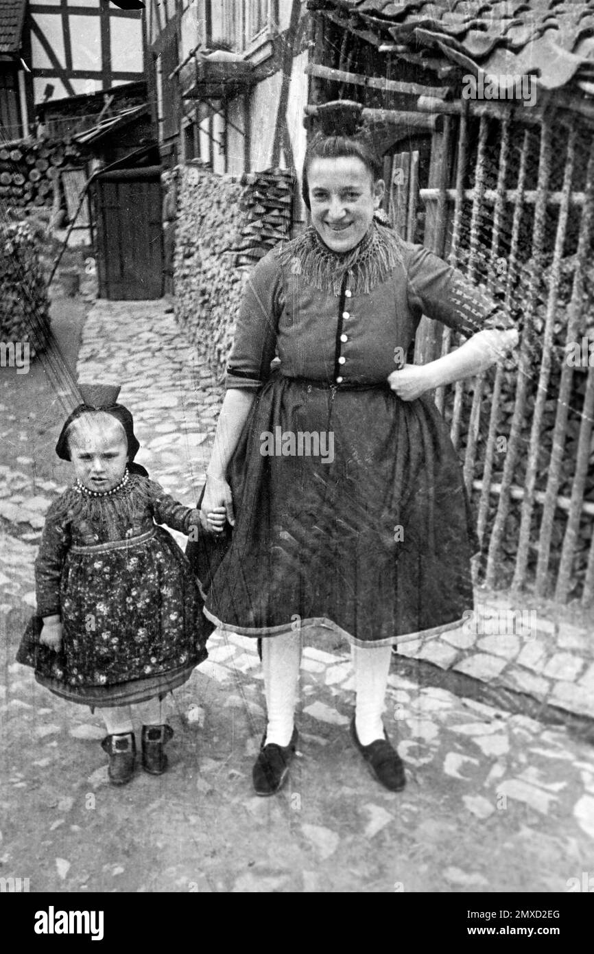Mutter und Tochter in Tracht im Schwalm-Eder-Kreis in Hessen, 1938. Mutter und Tochter in traditioneller Kleidung in der Region Schwalm-Eder in Hessen, 1938. Stockfoto