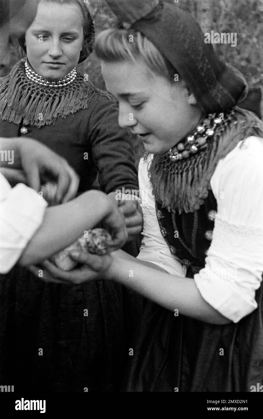 Junge Frau in Tracht mit gefundenen Ostereiern, Schwalm-Eder-Kreis in Hessen, 1938. Junge Frau in traditionellem Kostüm mit gefundenen Ostereiern, Schwalm-Eder-Region in Hessen, 1938. Stockfoto
