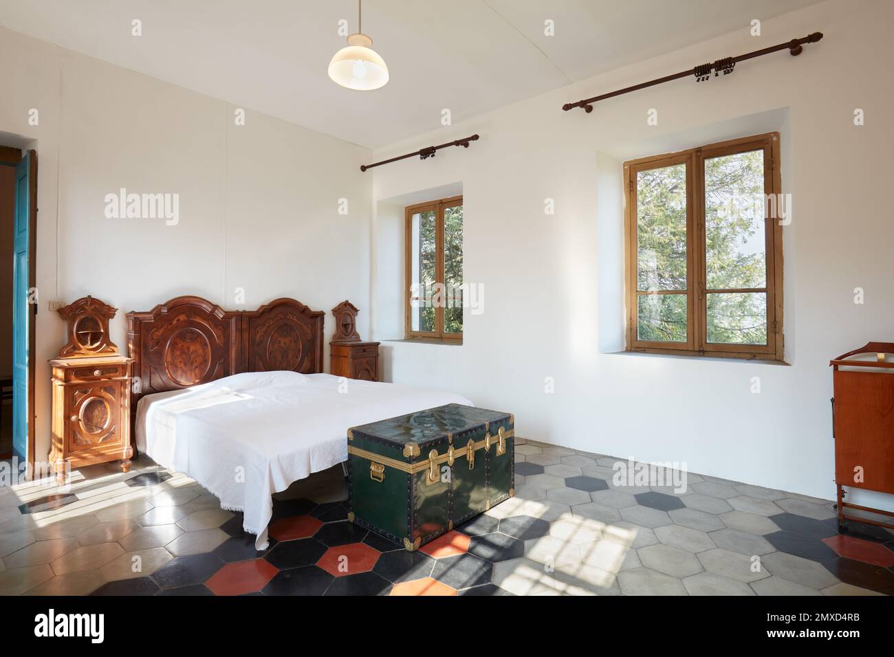 Schlafzimmer im Apartment-Interieur im alten Landhaus an einem sonnigen Tag Stockfoto
