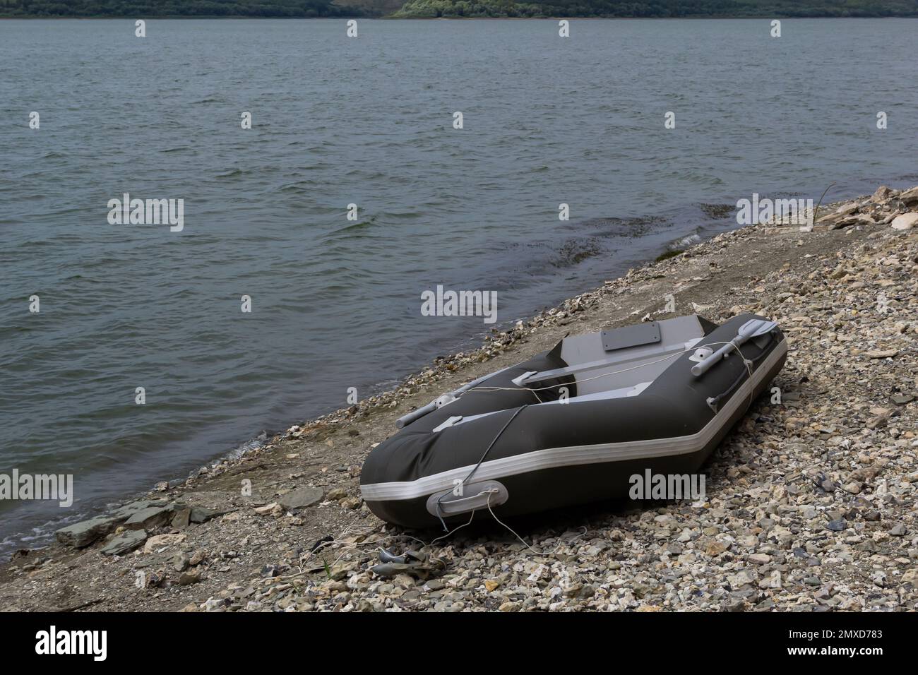 Ein Gummischiff steht am Ufer des Flusses. Ein Transportmittel auf dem Wasser. Stockfoto