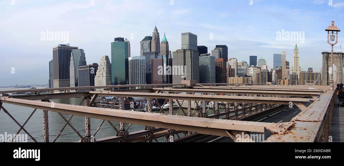 Die glitzernde Skyline von Manhattan von der Brooklyn Bridge – funkelnde Lichter, berühmte Wolkenkratzer und der glitzernde Fluss zeichnen ein pulsierendes Meisterwerk der Stadt aus Stockfoto