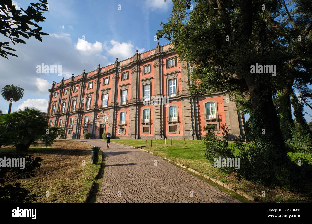 Die Außenfassade des roten Museums, mit Kopfsteinpflaster, Pfad. Im Kunstmuseum, Museo e Real Bosco di Capodimonte, in Neapel, Italien. Stockfoto